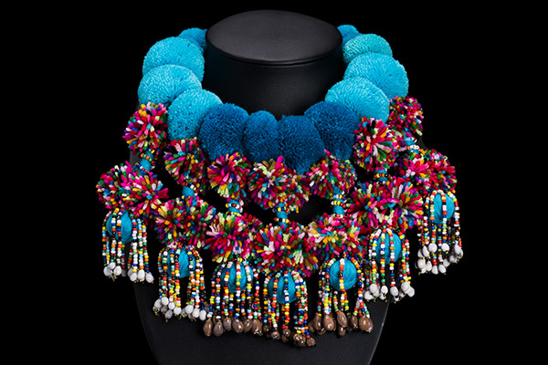 A Necklace Of Blue Wool Pompoms With Seven Pendants Of Multiticoloured Pompoms And Glass Beads