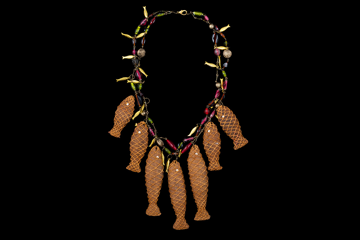 A Necklace Of Multicoloured Glass And Resin Beads And Small Golden Metal Fish With Seven Wood Fish Pendants