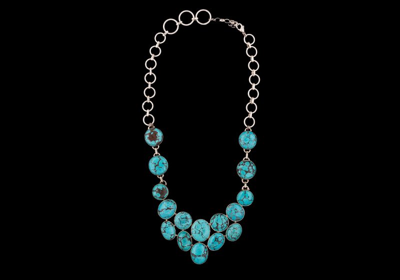 A Long Necklace Of Sixteen Linked Turquoise Circular And Oval Cabochons On A Silver Rings Necklace