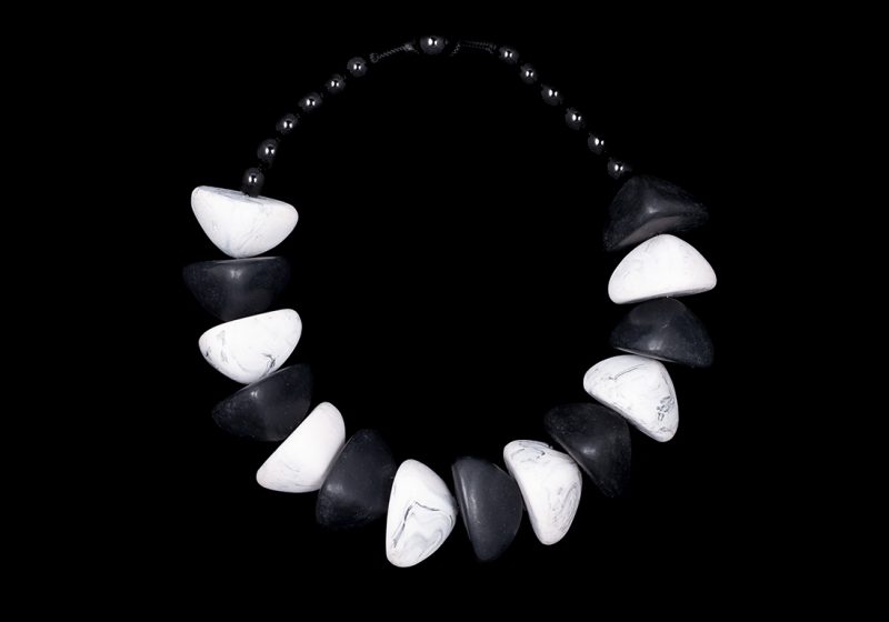 A Necklace Of Seven Black, And Seven White Large Domed Triangular Shaped Resin Beads