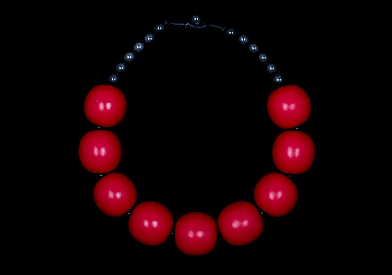 A Necklace Of Nine Red Resin Large Round Beads With Black Onyx Small Round Spacers And Beads