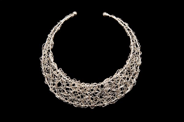 Silvered Metal Curved Interlocking Bands Attached To A Two Banded Torque Open Necklace