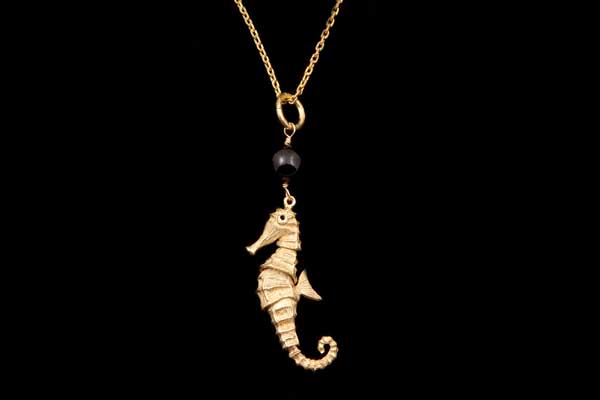 Golden Metal Articulated Sea Horse Pendant Suspended From A Long Chain Links Necklace