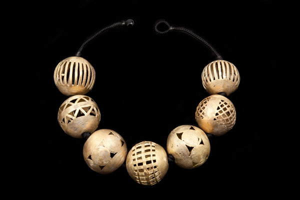A Knotted Necklace Of Seven Large Baule Tribal Perforated Patterned Round Brass Beads