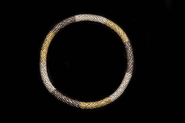 A Tubular Coiled Necklace Of Golden Metal, Silvered Metal, And Gunmetal Small Facetted Beads