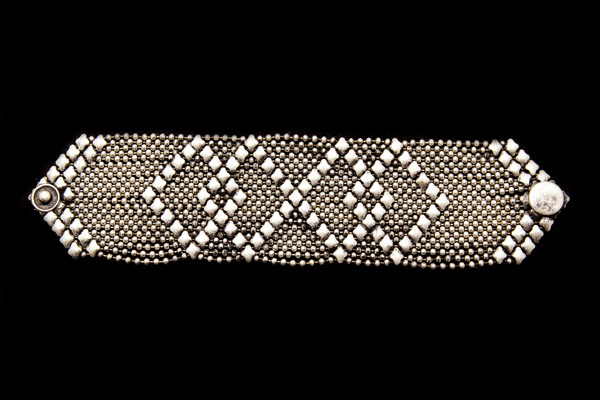 A Wide, Flat Silvered Metal Bracelet Made Up Of Small Round Beads And Larger Diamond Shaped Beads