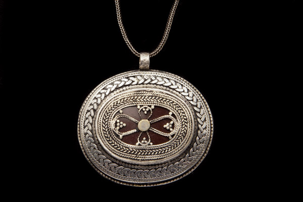 An Afghan Traditional Tribal Patterned Silver Oval Pendant On A Silver Snake Links Chain Necklace