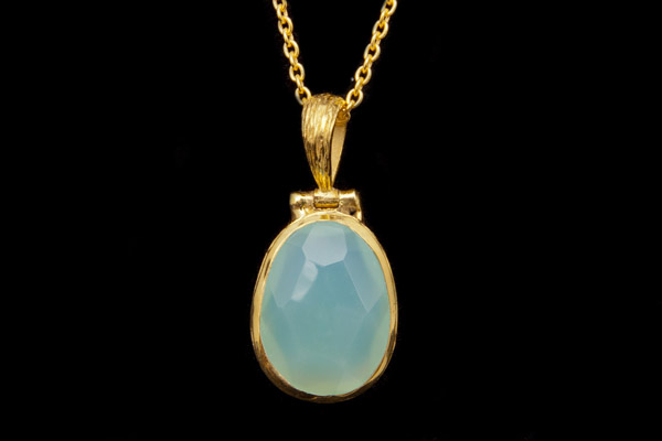 A Chalcedony Domed Facetted Oval Pendant In A Gold Plated Frame On A Gold Plated Fine Chain Necklace
