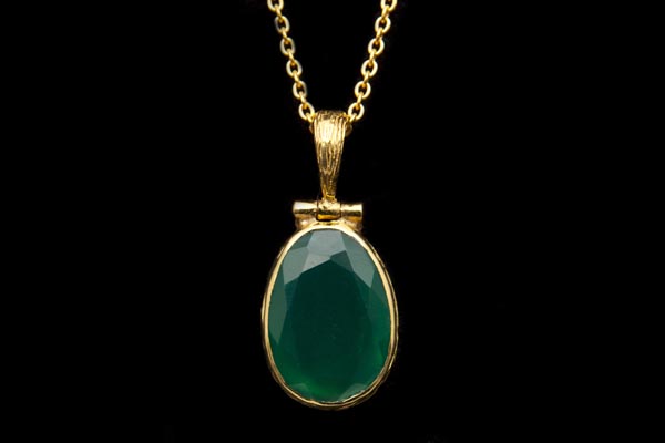 A Green Onyx Domed Facetted Oval Pendant In A Gold Plated Frame, On A Gold Plated Chain Necklace