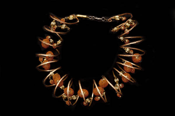 A Golden Metal Coiled Band Necklace With Copper Coloured Round Beads And Golden Metal Fluted Beads
