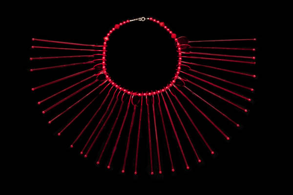 A Fan Shaped Necklace Of Clear Red Plastic Long Thin Drops With Red Resin Round Bead Spacers