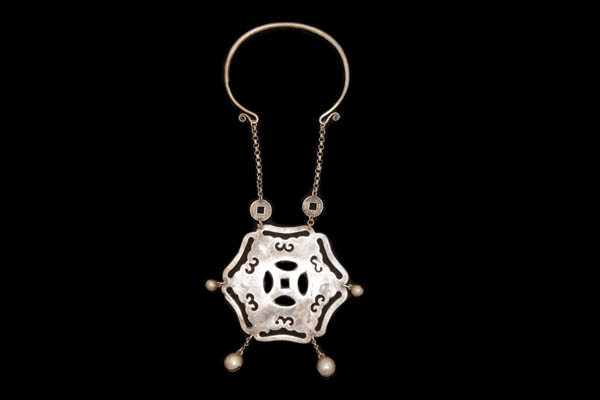 A Miao Silvered Metal Large Hexagonal Shaped Pendant On A Curved Band And Chain Necklace