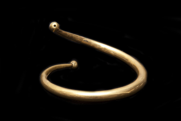 A Brass Spiral Graduated Hollow Band Bangle, Decorated, At Each End, With A Brass Round Bead