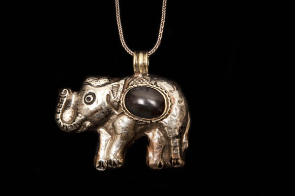 A Nepalese Silvered Metal Elephant Pendant Necklace, Inlaid With A Black Resin Domed Oval Cabochon