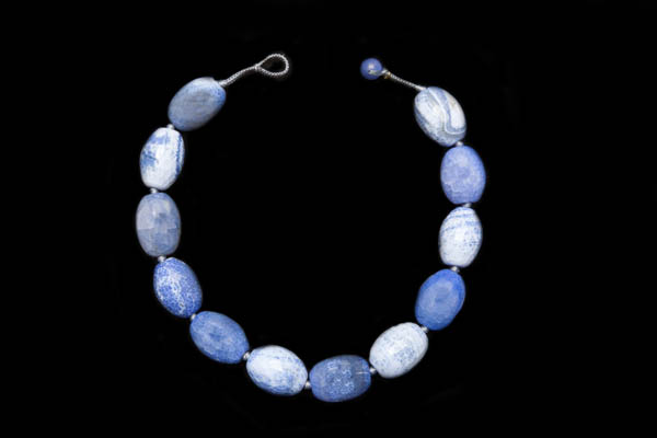 A Knotted Necklace Of Twelve Light And Dark Chalcedony Blue Dyed Agate Large Facetted Oval Beads