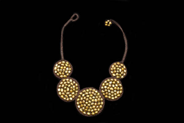 A Brown Braided Cord Necklace Necklace With Five Circular Braided Discs Inlaid With Gold Dyed Pearls