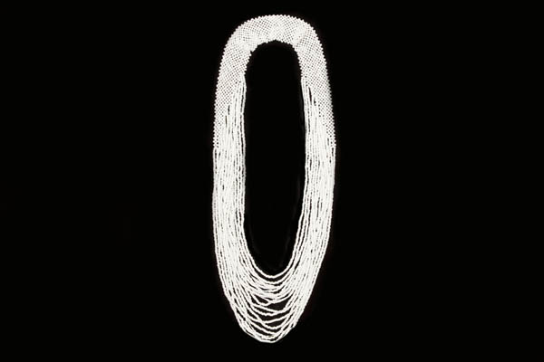 A Long Necklace Of Sixteen Graduated Strands Of Small White Resin Beads With A Crochet Bead Band Top