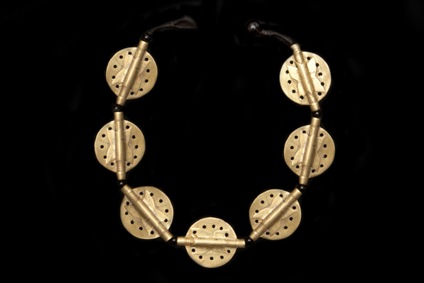 A Necklace Of Seven Baule Tribal Perforated Brass Patterned Discs With Black Agate Round Spacers