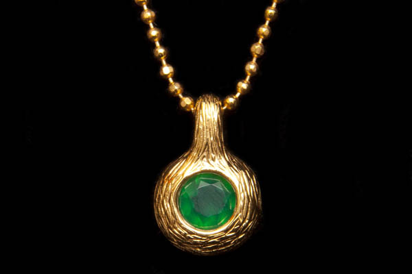 A Gold Plated Circular Grooved Surface Pendant Inlaid With A Green Onyx Facetted Cabochon On A Gold Plated Small Round Beads Necklace