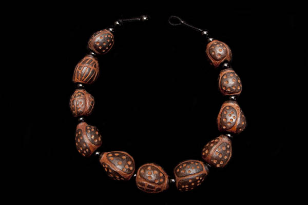 A Necklace Of Eleven Large Ethiopian Brown Nuts Hand Carved With Traditional Tribal Patterns And Black Onyx Round Spacers