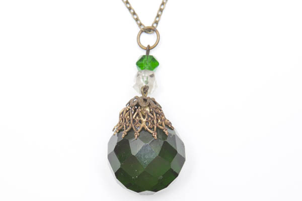 A Long Brass Chain Necklace With A Dark Green Facetted Glass Teardrop Pendant