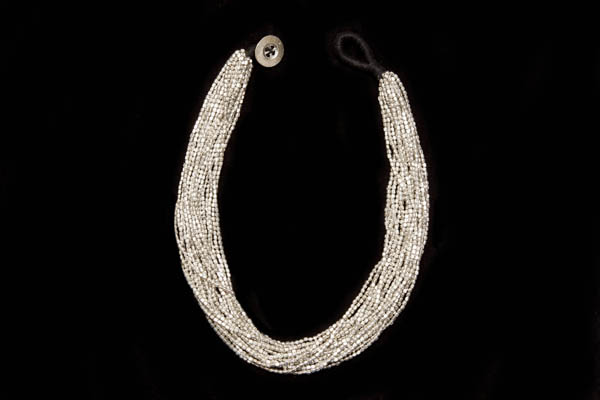 A Necklace Of Seventeen Strands Of Small RectangularSilvered Metal Beads