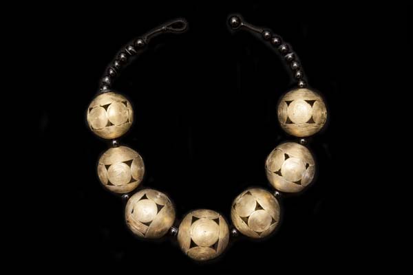 A Necklace Of Seven Baule Large Brass Patterned Round Hollow Beads With Black Onyx Round Spacers And Beads
