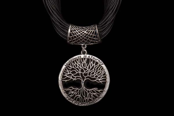 A Silvered Metal 'Tree Of Life" Filigree Circular Pendant Suspended From A Leather Thirty-Three Strand Necklace