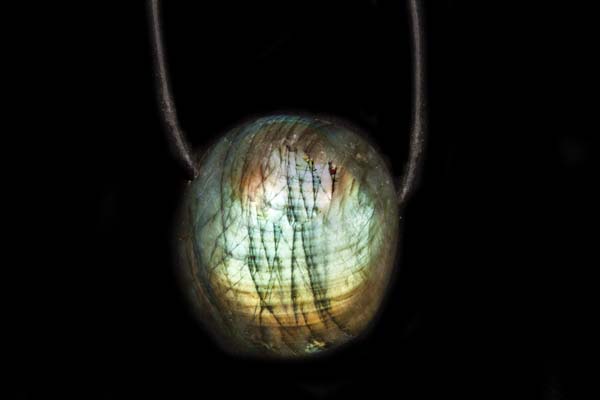 A Madagascar Labradorite Deep Domed Circular Pendant Suspended From A Black Leather Thong Necklace
