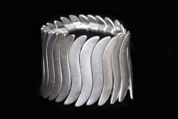 A Wide Elasticated Bracelet Of Twenty-Five Silvered Metal 'S' Shaped Flat Bars