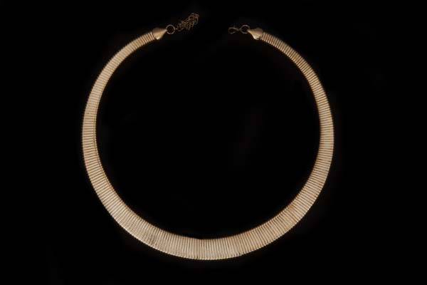 A Golden Metal Flat Circular Necklace Made Up From Interlocking Rectangular Tapered Bands