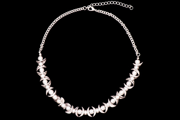 A Silvered Metal Chain Necklace With Silvered Metal Round Beads And Curved Oval Narrow Bars