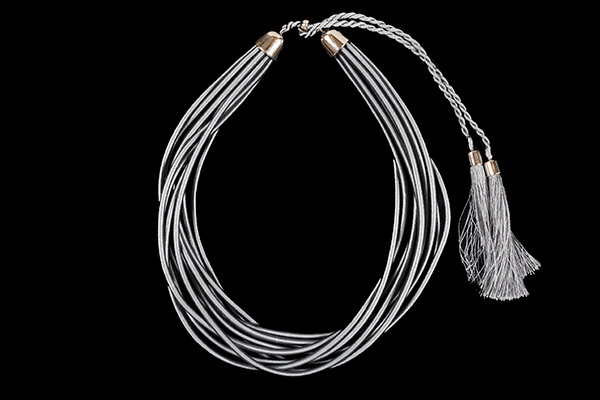 A Necklace Of Ten Silvered Thread Covered Cords Enclosed At Each End In Silvered Metal Caps