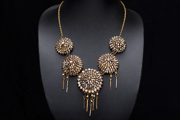 An Indonesian Golden Metal Necklace Of Five Domed Circular Plaques With Facetted Glass Inlays