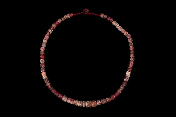 A Necklace Of Sixty-Three Ancient Roman Excavated Red Glass Mixed Shaped And Sized Beads