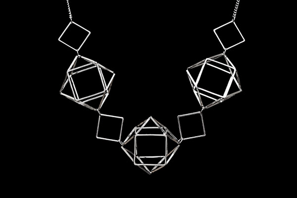 A Silver Chain Links Necklace With Three Silver Cuboctahedron 'Cage' Beads And Diamond Shape Beads