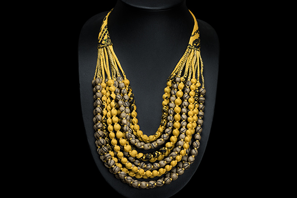 A Long Necklace Of Twelve Graduated Strands Of Yellow And Grey Sari Silk Covered Wood Beads