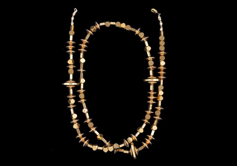 A Long Necklace Of Mixed Shaped And Sized Golden Metal Beads