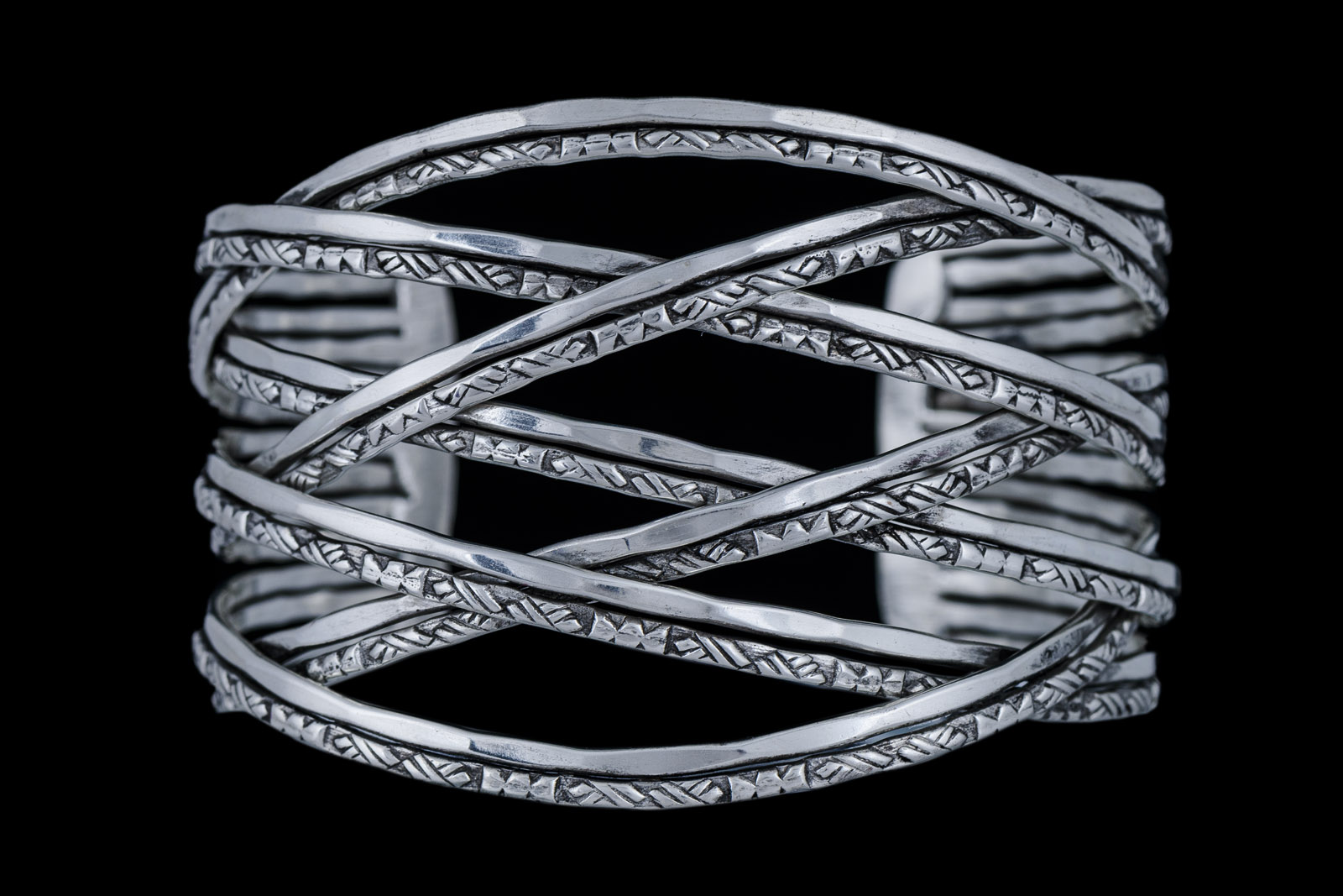 A Silvered Metal Tapered Open Cuff Of Seven Interlocking Double Bands-One Band Patterned And One Band Plain