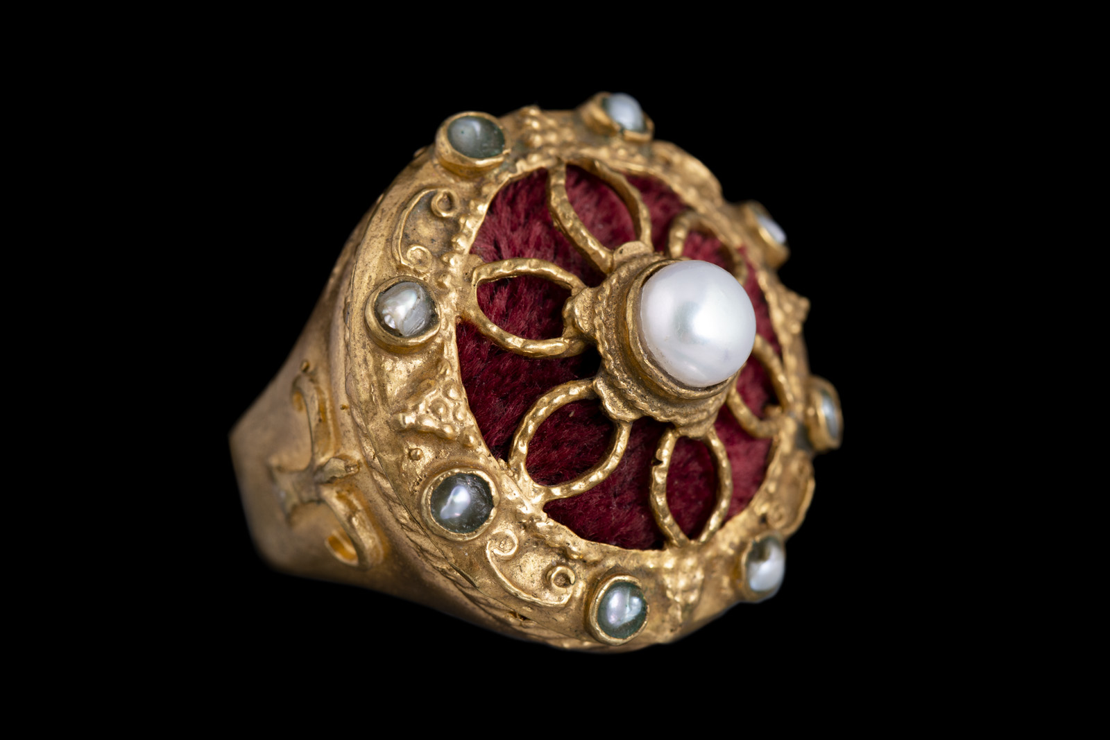 An Afghan Golden Metal Circular Bezel Ring With Freshwater Pearls, Red Cloth, And Golden Metal Patterned Bands