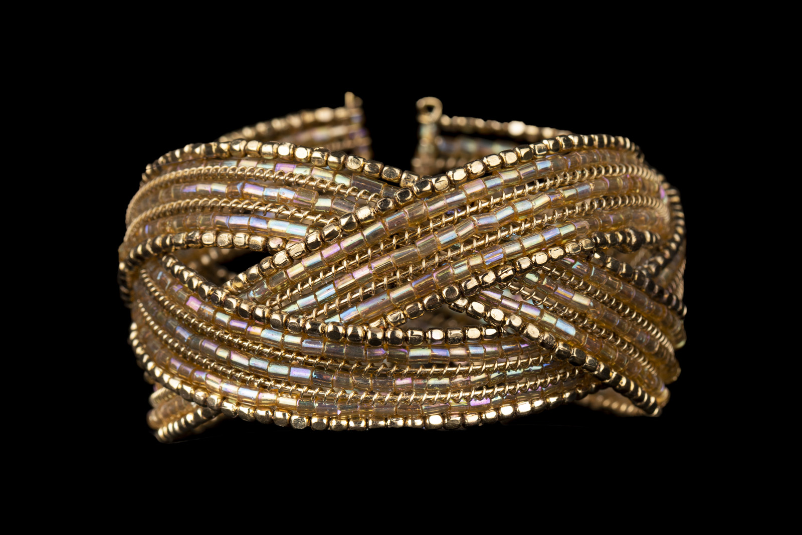 An Open Cuff With Three Interlocking Bands Of Small Golden Metal And Opalescent Glass Beads