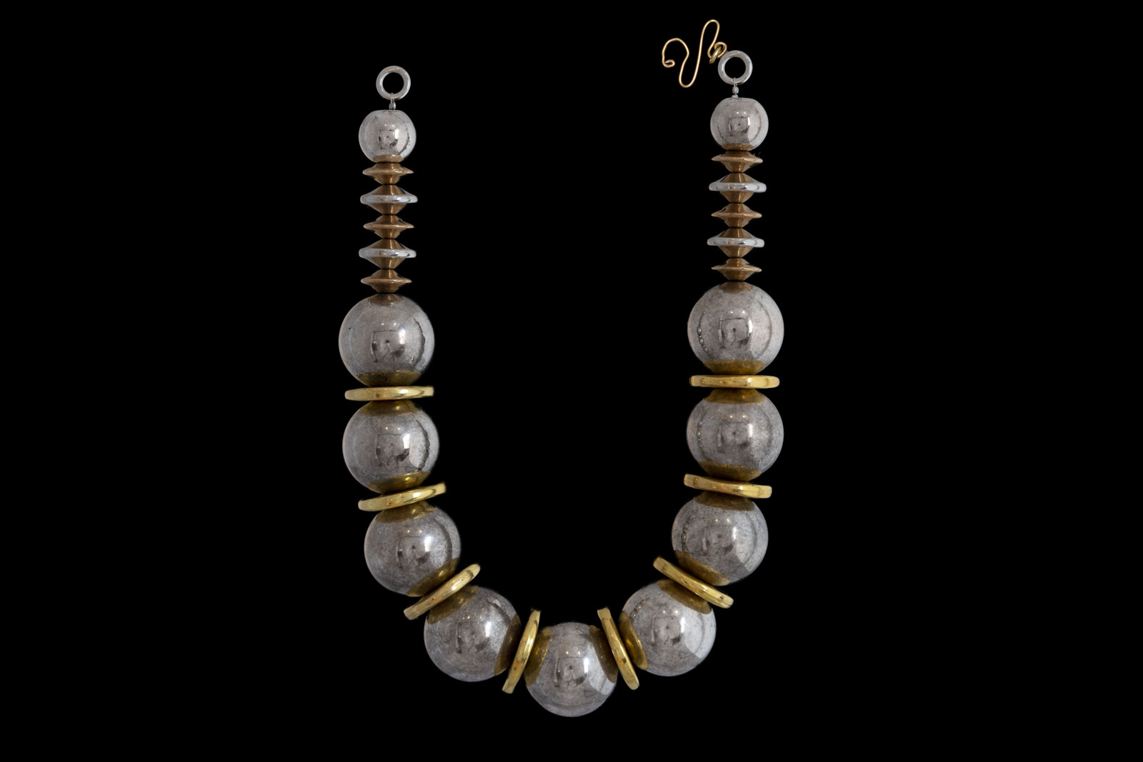 A Necklace Of Nine Large Silvered Metal Round Hollow Beads And Eight Golden Metal Large Disc Spacers