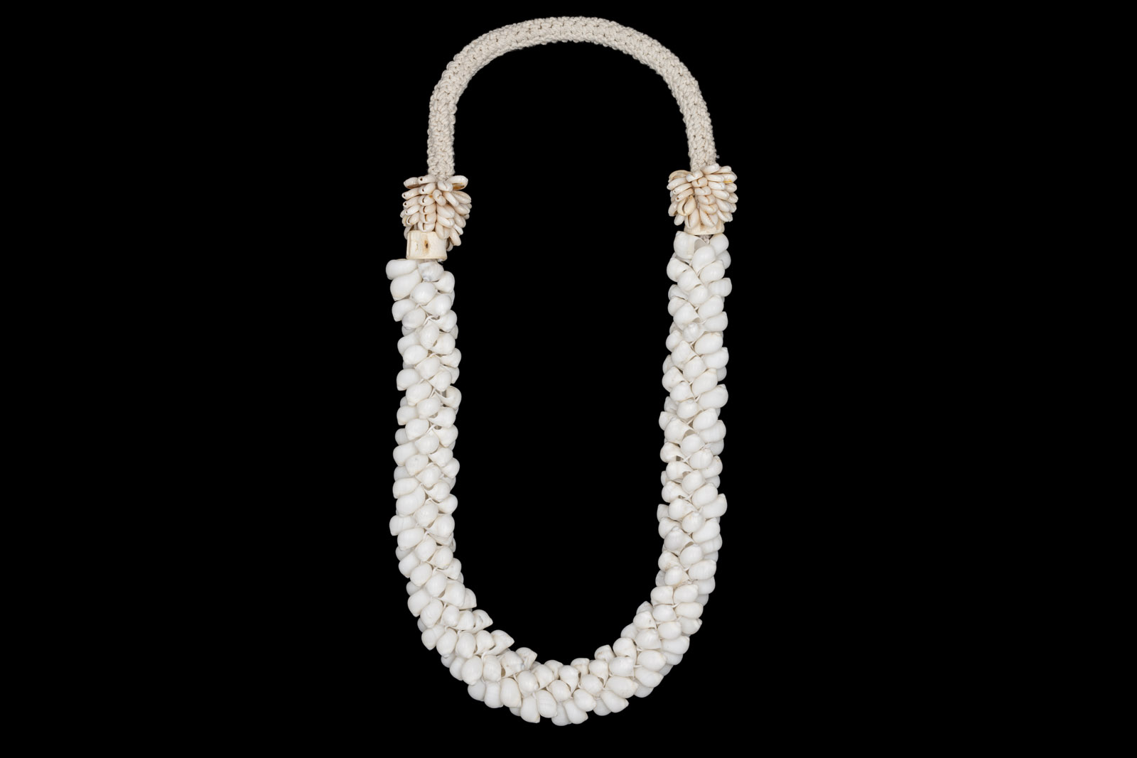 A New Guinea Long Necklace Of White Braided Rope, With Small White Curled Shells, And Small Cream Cowrie Shells