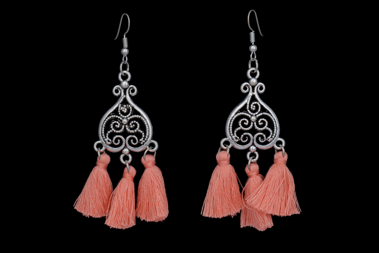 A Pair Of Silvered Metal Filigree Patterned Heart Shaped Earrings, Each With Three Pendants Of Coral Pink Silk Strands.