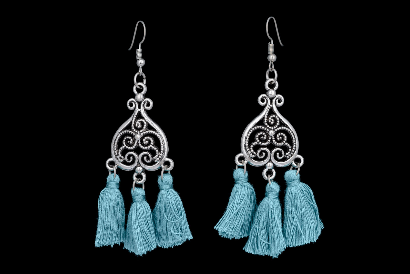 A Pair Of Silvered Metal Filigree Patterned Heart Shaped Earrings, Each With Three Pendants Of Light Blue Silk Strands.