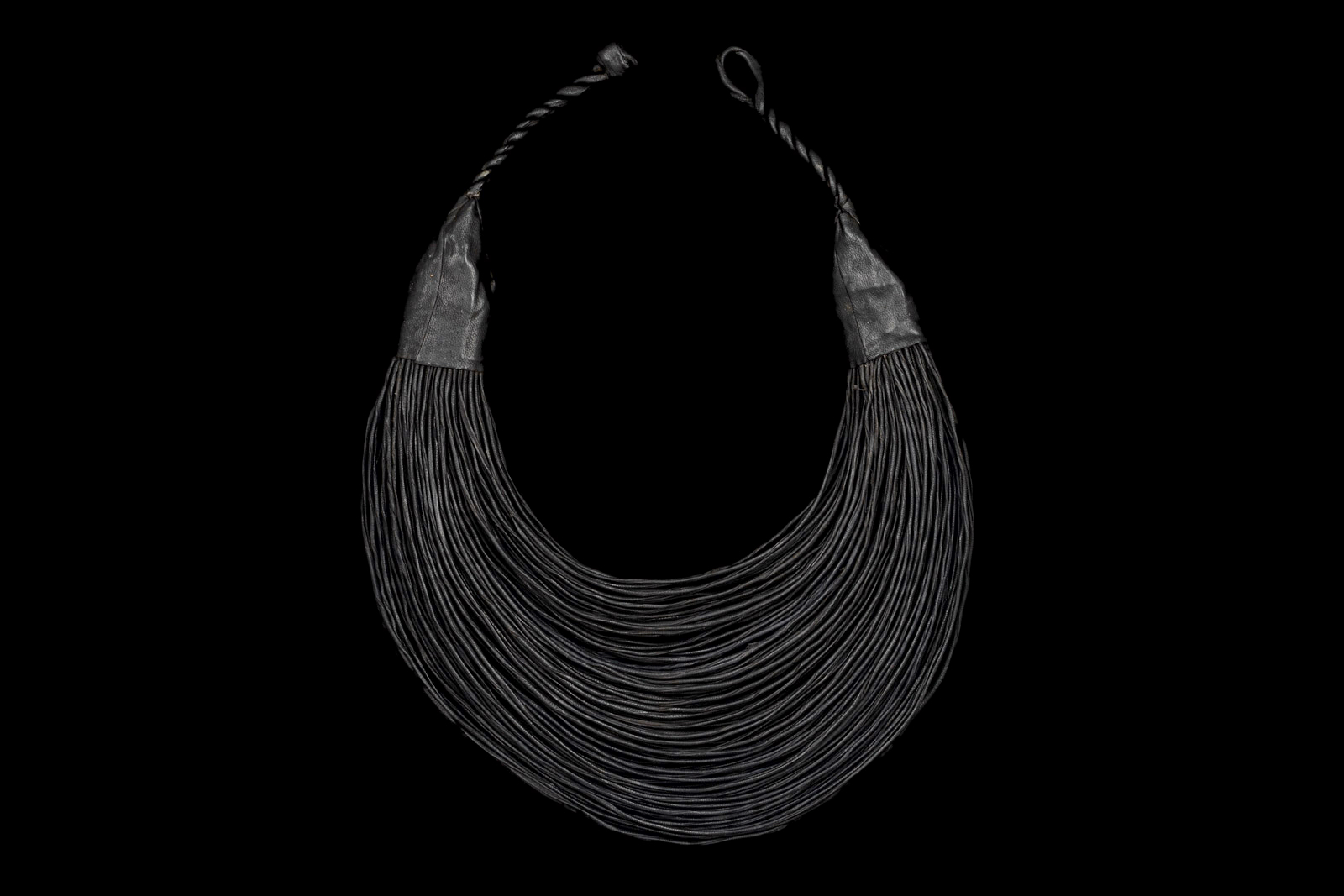 A West African Necklace Of One Hundred And Fourteen Curved And Graduated Black Leather Bands.
