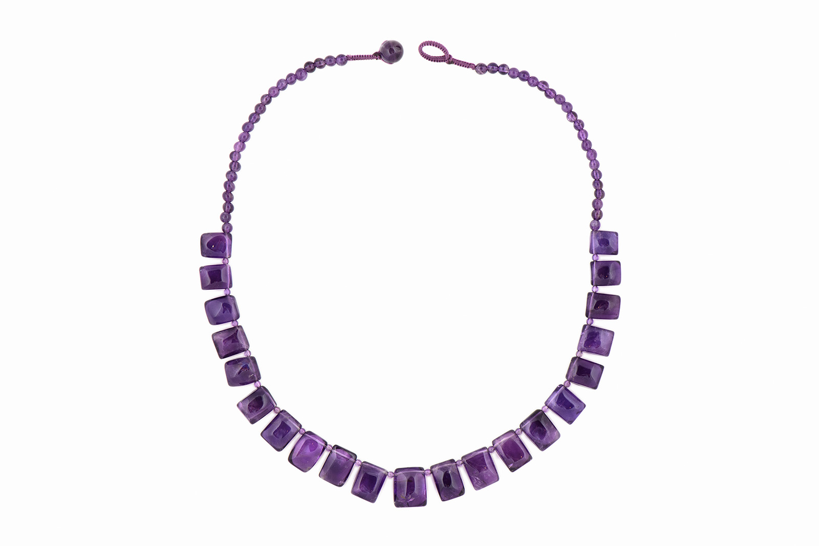 A Necklace Of Twenty-One Graduated Domed Rectangular Amethyst Drops With Small Amethyst Round Spacers And Beads.