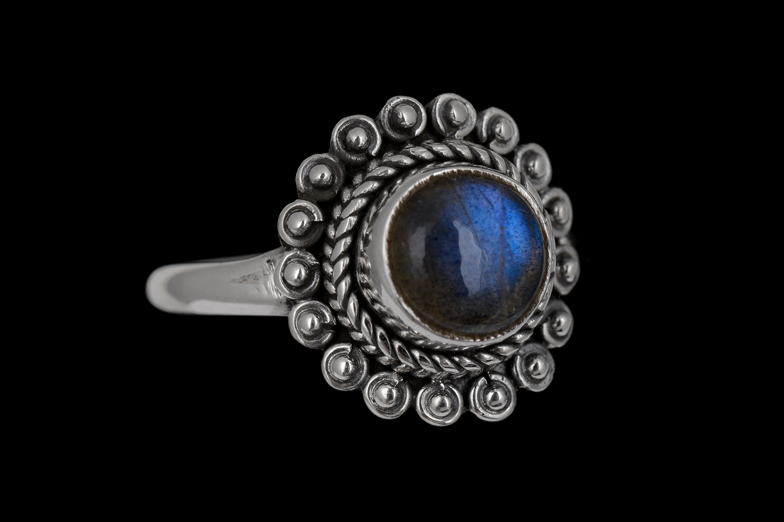 A Small Silver Ring With A Circular Patterned Bezel, And A Raised Centre Inlaid With A Domed Circular Labradorite Cabochon.