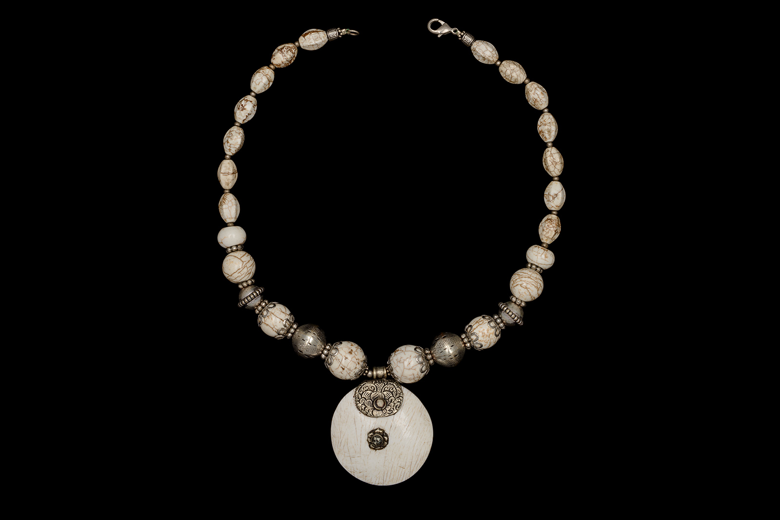 An Afghan Necklace Of White And Brown Patterned Agate Beads And Silver Beads With A Circular White Shell And Silver Pendant.