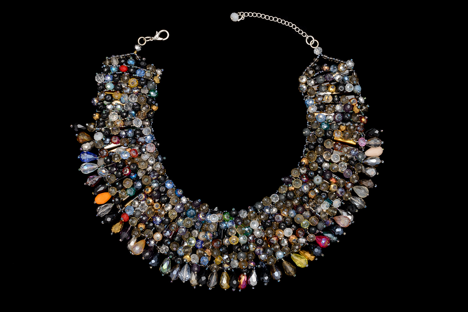 A Thai Curved Tapered Band Necklace, Decorated With Vertical Bands Of Different Coloured Plain And Facetted Round Glass Beads And Teardrop Facetted Pendants.